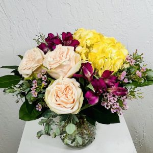 Pastel jar with pink roses, purple alstroemeria, and yellow hydrangea designed by La Paloma Blanca Floral Designs in Scottsdale AZ