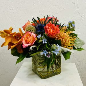 A vibrant vase filled with an assortment of colorful flowers, showcasing La Paloma Blanca's floral artistry and design.