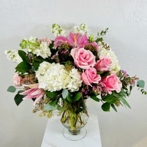 Pink and White Bouquet. Clear glass pedestal vase with white hydrangea, pink roses, white stock, pink stargazer lilies, and pink spray roses designed by La Paloma Blanca Floral Designs in Scottsdale, AZ