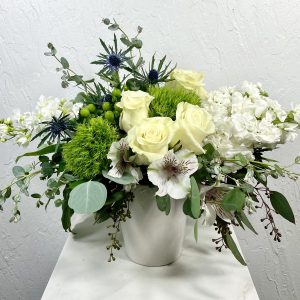White ceramic pot with white alstroemeria, blue thistle, white roses, green trick, and white stock designed by La Paloma Blanca Floral Designs in Scottsdale AZ