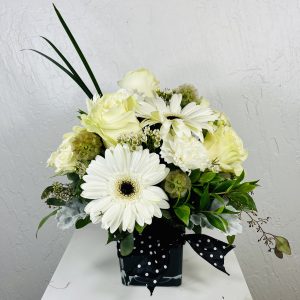black cube with white flowers: gerbera daisies, roses, carnations and scabiosa pods designed by La Paloma Blanca Floral Designs in Scottsdale, AZ