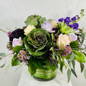 purple kale, purple stock, pink and lavender roses, scabiosa, and succulents