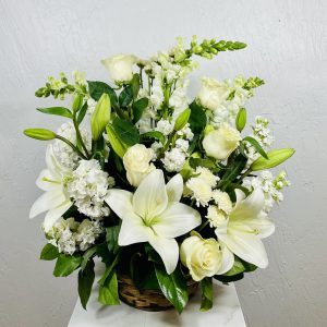 Round basket with white lilies, snapdragons, roses, button mums, stock and carnations designed by la paloma blanca floral designs in scottsdale az
