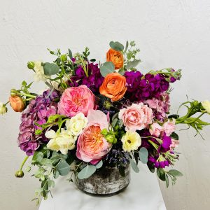 pink garden roses, purple hydrangea, butterfly ranunculus, ranunculus, and stock in a cylinder vase designed by La Paloma Blanca Floral Designs in Scottsdale, AZ