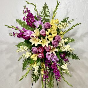 Standing spray of yellow lilies, yellow stock, lavender roses, lavender gladiolus, and purple stock designed by la paloma blanca floral designs in scottsdale az